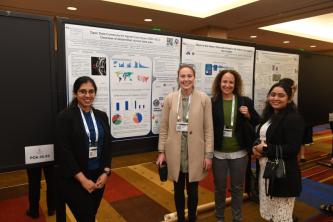 Ferguson lab members pose for a photo in front of a poster