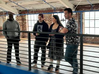 A group of people standing and talking while looking over a bannister