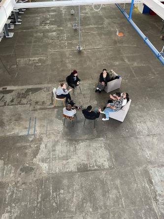 View from the balcony above of Ferguson lab members sitting together in a circle chatting