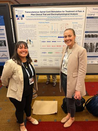 Ferguson lab members Luisa M Rojas Valencia, PhD, and Anastasia Keller, PhD stand in front of a poster
