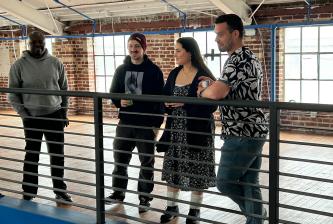 A group of people standing and talking while looking over a bannister